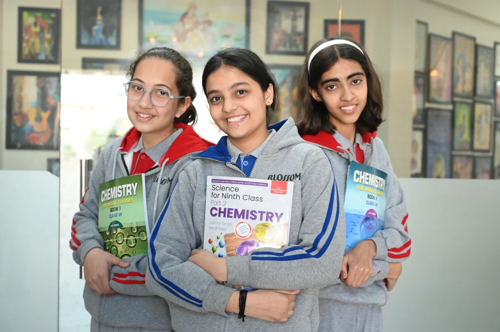 Happy students of Blossom Academy holding chemistry textbooks, representing the best school in Suratgarh with a strong focus on academic excellence, science education, and holistic student development.